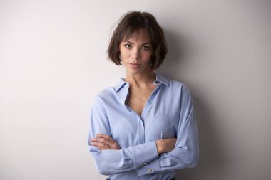 Kendine güvenen genç işkadını kamera duran kolları olan bakarak yakın çekim studio portresi izole arka plan geçti.