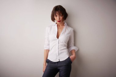 Beyaz gömlek ve kırmızı ruj dururken izole arka plan giyen çekici kadın stüdyo portre çekim. 