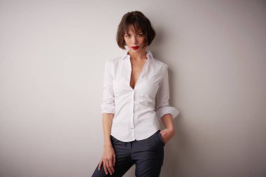 Beyaz gömlek ve kırmızı ruj dururken izole arka plan giyen çekici kadın stüdyo portre çekim. 