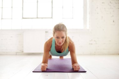 Çekici orta yaşlı kadın fitness salonunda yoga mat tahta egzersizleri yapıyor portre çekim.