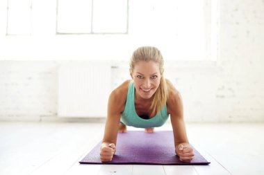 Çekici orta yaşlı kadın fitness salonunda yoga mat tahta egzersizleri yapıyor portre çekim.