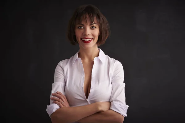 Portrait studio d'une femme joyeuse debout les bras croisés — Photo