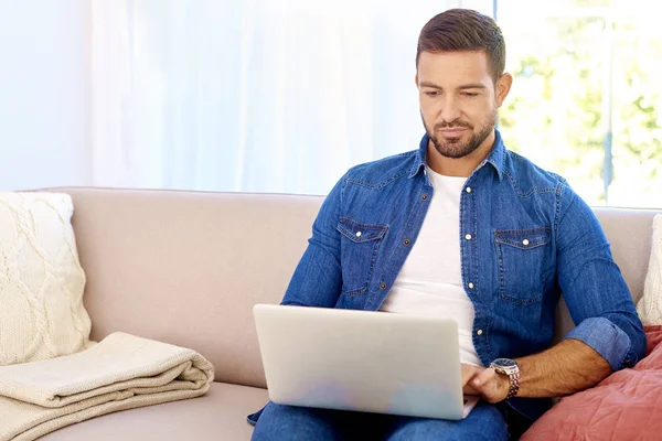 Hombre guapo usando su portátil mientras trabaja desde casa —  Fotos de Stock