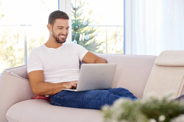 Όμορφος άνθρωπος χρησιμοποιεί το laptop του, ενώ εργάζονται από το σπίτι — Φωτογραφία Αρχείου