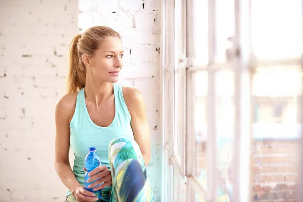 Привлекательная спортивная женщина расслабляющая и питьевая вода после работы — стоковое фото