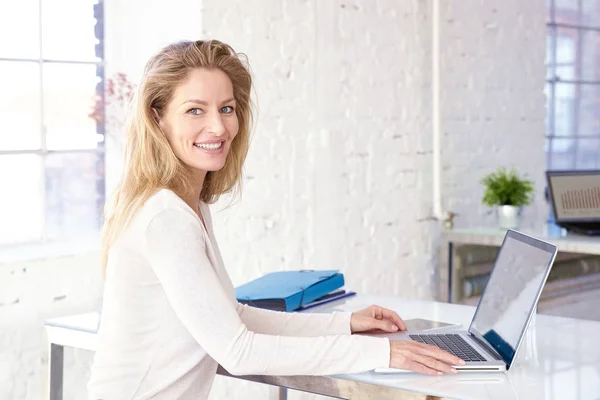 Selbstbewusste Geschäftsfrau sitzt am Schreibtisch und arbeitet an fi — Stockfoto