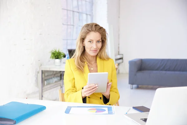Деловая женщина с помощью цифрового планшета во время работы в офисе — стоковое фото
