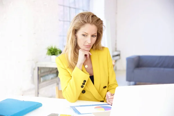 Bizneswoman patrząc starannie podczas pracy na laptopie — Zdjęcie stockowe