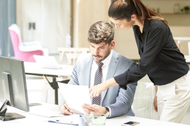 İş kadını iş projesiyle ilgili danışmanlık yaparken mali danışman iş adamının ofis masasında oturması. Ofiste takım çalışması..