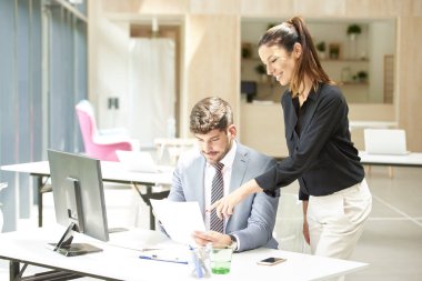 İş kadını iş projesiyle ilgili danışmanlık yaparken mali danışman iş adamının ofis masasında oturması. Ofiste takım çalışması..