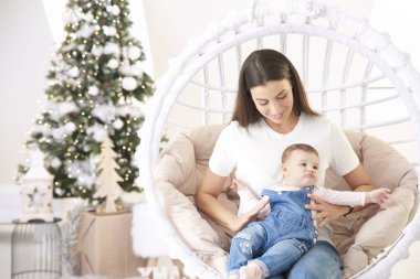 Gülümseyen anne ve küçük kızı Noel 'le evde dinleniyorlar.