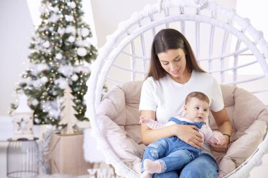 Gülümseyen anne ve küçük kızı Noel 'le evde dinleniyorlar.