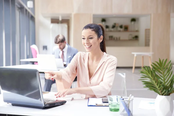 Успішна бізнес-леді робить дзвінок під час роботи на ноутбуці — стокове фото