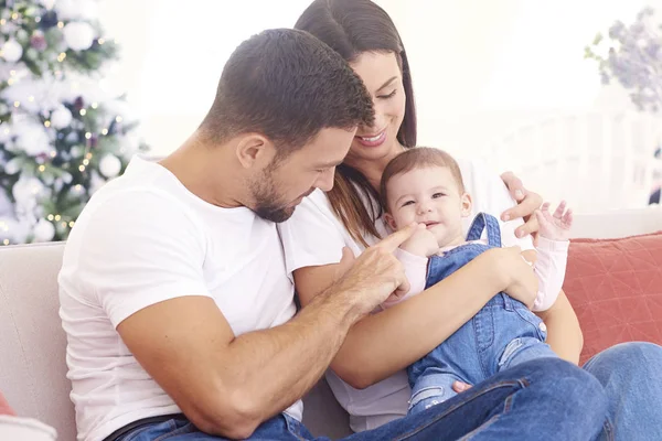 Lovely family with their baby girl relaxing on sofa at home duri — Stock Photo, Image