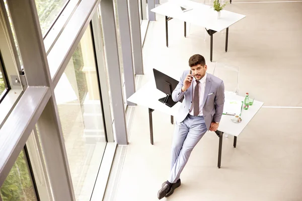 Tiro de comprimento total de homem de negócios em pé no escritório e makin — Fotografia de Stock