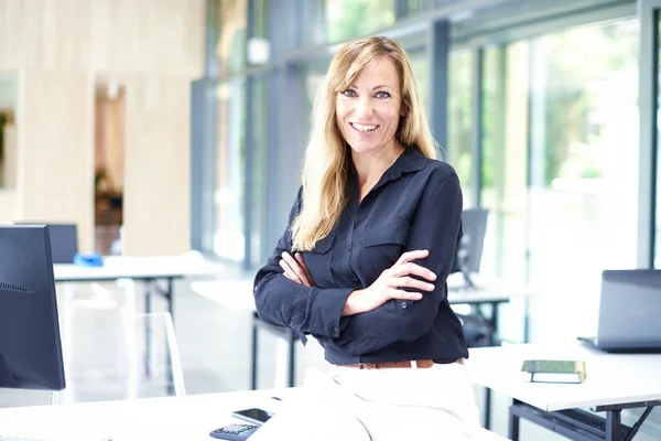 Zelfverzekerde volwassen zakenvrouw staat in het kantoor — Stockfoto