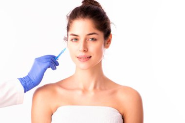 Portrait shot of an attractive woman receiving botox treatment for prevention. Isolated on white background. 