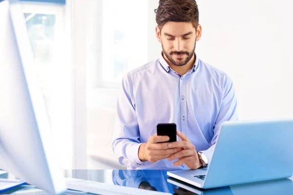 Junger Geschäftsmann Trägt Hemd Während Schreibtisch Hinter Laptop Und Sms — Stockfoto