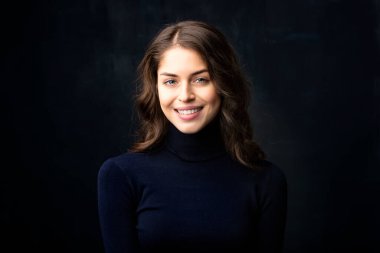 Balıkçı yaka kazak giyen güzel bir genç kadının portresi..