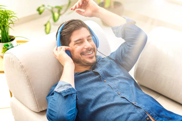 Foto Joven Guapo Con Auriculares Escuchando Música Mientras Relaja Casa — Foto de Stock