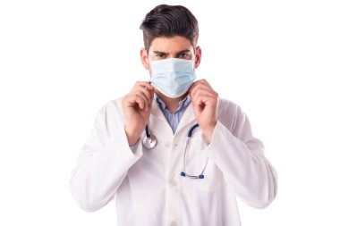 İzole edilmiş beyaz arka planda dururken erkek doktorun yüz maskesi takması.. 