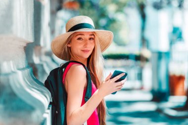 Sokakta durup mesajlaşırken hasır şapka takan güzel bir genç kadının yakın plan portresi..