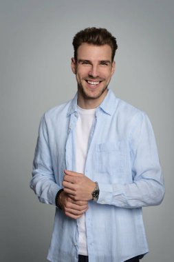 Tecrit edilmiş arka planda duran yakışıklı bir gencin stüdyo fotoğrafı. Tişört giyen ve kameraya bakan kendinden emin bir erkek. Uzayı kopyala İzole edilmiş arkaplan. 