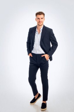 Takım elbise ve gömlek giyen sakallı iş adamının portresi ve izole edilmiş beyaz arka plana karşı durmak. Stüdyo fotoğrafı, izole edilmiş arka plan. Uzayı kopyala Tam menzil.. 