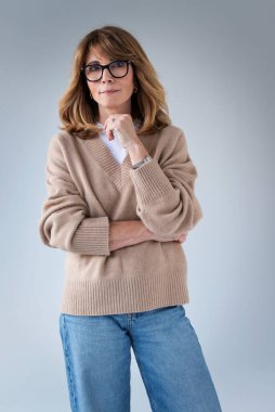 Sarışın kadın, izole edilmiş arka planda duruyor ve kameraya bakıyor. Gömlek ve kot pantolon giyen orta yaşlı bir kadın. Boşluğu kopyala. 