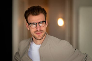 Yakışıklı bir delikanlının vesikalığı. Beyaz gömlek ve ceket giyen ve içeride duran kendine güvenen bir adam.. 