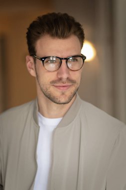 Yakışıklı bir delikanlının vesikalığı. Beyaz gömlek ve ceket giyen ve içeride duran kendine güvenen bir adam.. 