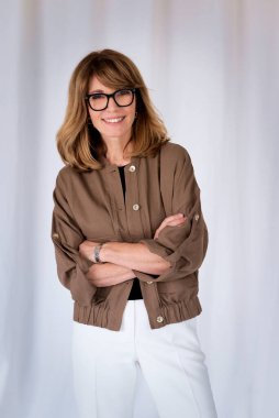 Sarışın kadın, izole edilmiş arka planda duruyor ve kameraya bakıyor. Orta yaşlı kadın iş kıyafeti giyiyor. Boşluğu kopyala. 