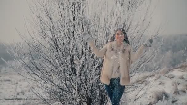 Девушка играет со снегом — стоковое видео