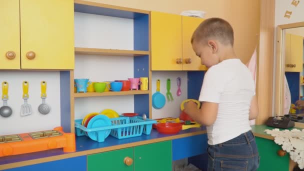 Der kleine Junge spielt, was kocht — Stockvideo