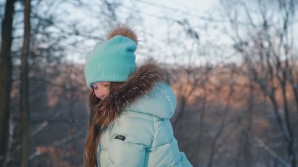 Портрет маленькой девочки, дующей на снег — стоковое видео