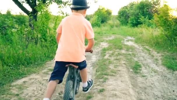 Liten pojke som rider en cykel utan pedaler — Stockvideo