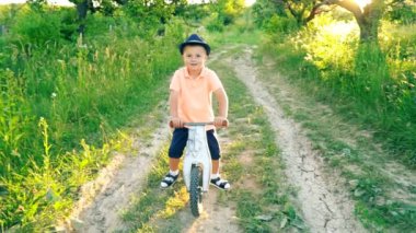 küçük çocuk pedallar olmadan bir bisiklet sürme