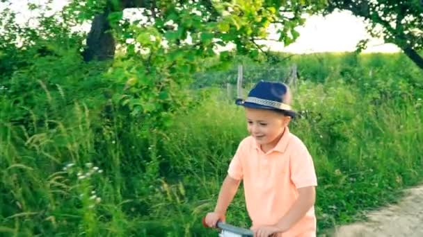Liten pojke som rider en cykel utan pedaler — Stockvideo