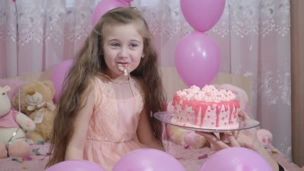 Маленька дівчинка пробує торт — стокове відео