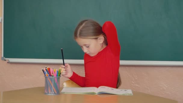 Маленька дівчинка щось малює — стокове відео
