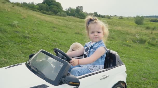小さな女の子が車を運転します。 — ストック動画