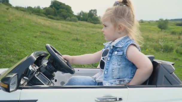 The little girl is driving a car — Stock Video