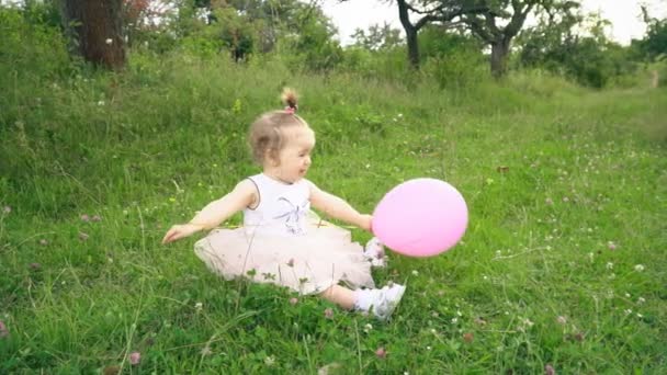Маленькая девочка играет с воздушным шаром — стоковое видео