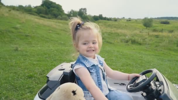 Das kleine Mädchen fährt Auto — Stockvideo