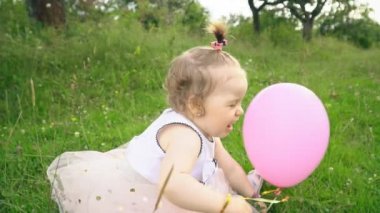 Küçük kız bir balonla oynuyor.