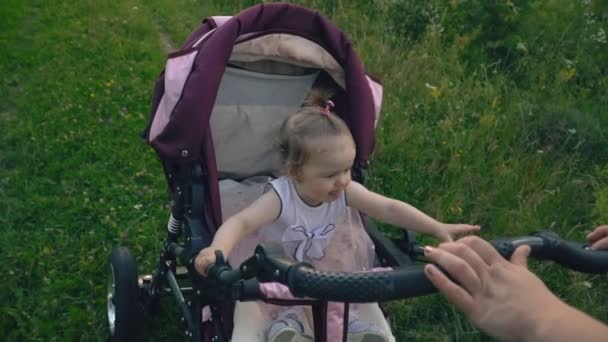 Маленька дівчинка їде в колясці — стокове відео