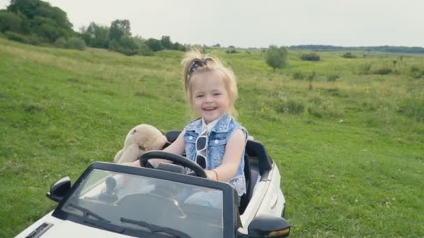Das kleine Mädchen fährt Auto — Stockvideo