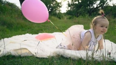 Küçük kız bir balonla oynuyor.