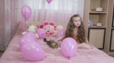 küçük kız bir kedi okşayarak