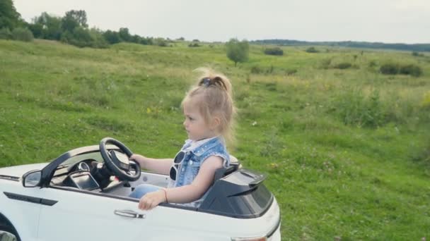 The little girl is driving a car — Stock Video